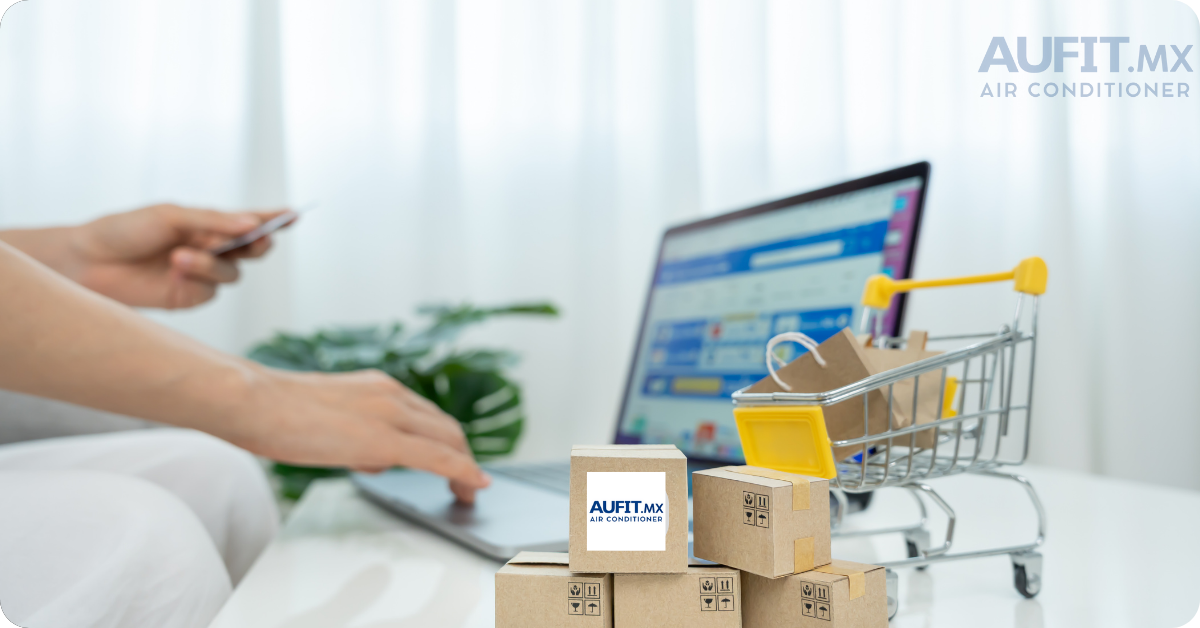 Persona usando laptop con pedidos y cajas junto a un carrito de compras en una mesa. Compra segura aufit.mx